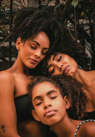 black women and girl with closed eyes in street